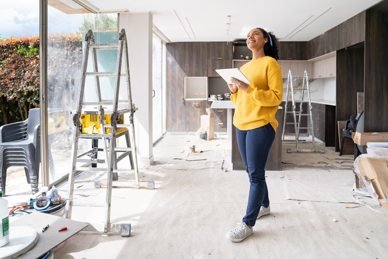 A woman smiles while renovating her home.